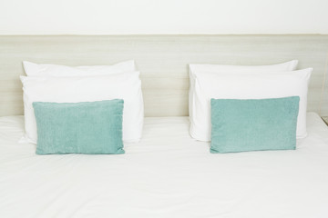 Fototapeta na wymiar White and green pillows on bed
