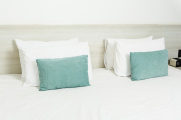 Fototapeta na wymiar White and green pillows on bed