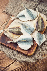 Vintage cutting board with dried horse mackerel, vertical shot