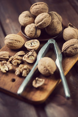 Walnuts and nutcracker, vintage wooden background, vertical shot