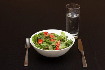 Serving with light salad with tomatoes in white china bowl and a