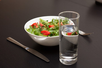 Serving with light salad with tomatoes in white china bowl and a