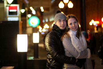 young lovers kissing on the street at night in the city, the str