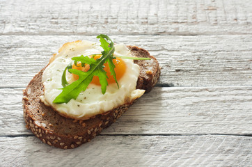 Sandwich with fried egg and arugula
