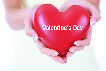 Heart in hands of girl close up