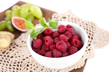 Raspberries in small bowl on napkin isolated on white
