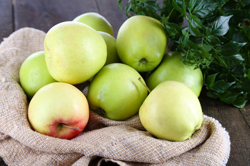 Juicy apples on sackcloth on wooden table