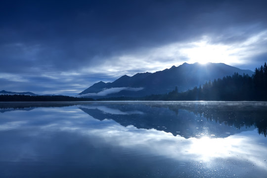 Fototapeta sunshine over mountains and alpine lake