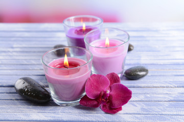 Obraz na płótnie Canvas Beautiful colorful candles, spa stones and orchid flower,on