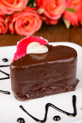 Sweet cake with chocolate on plate on table close-up