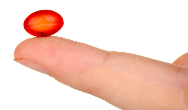 Woman's Hand Holding A Red Pill On White Background Close-up