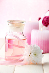 Obraz na płótnie Canvas Butelka szklana z kolorowym istocie, na różowym tle