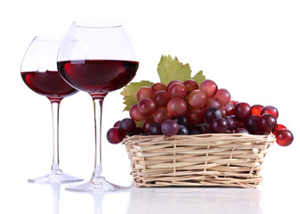 Wineglasses with red wine and  grape in wicker basket isolated