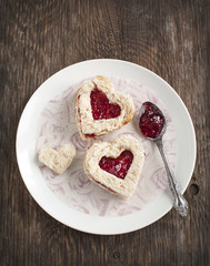 Heart shape sandwich with strawberry jam on a plate