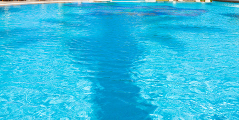 Fototapeta na wymiar reflets de palmier dans eau bleue de piscine