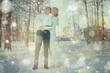 Love man and woman embracing outdoors winter snowfall