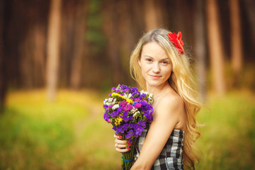 Naklejka premium Portrait of a young woman on a background of green nature