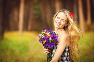 Naklejka premium Portrait of a young woman on a background of green nature