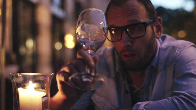 Drunk man with a glass of wine sitting in the restaurant 