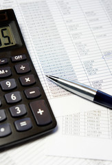 Office table with calculator, pen and accounting document