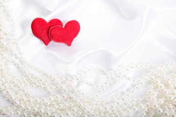 Red hearts on pearls background