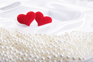 Red hearts on pearls background
