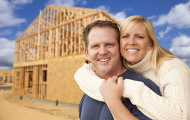 Couple in Front of New Home Construction Framing Site