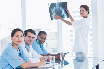 Fototapeta premium Female doctor explaining x-ray to her team
