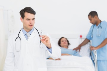 Fototapeta premium Doctor holding a syringe with patient in hospital