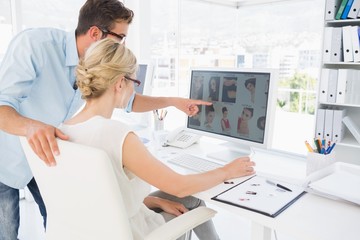 Side view of photo editors working on computer