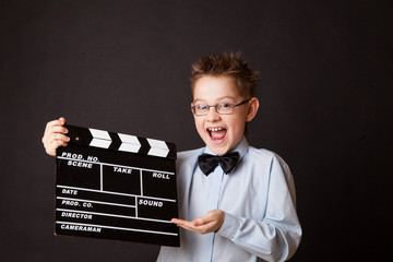 Little boy holding clapper board in hands.