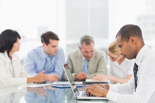 Businessman using laptop during a meeting