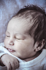 new born baby curled up sleeping on a blanket, multiple expressi