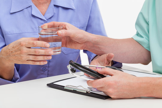 Doctor giving glass of water