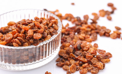 Raisins in a glass bowl over white background
