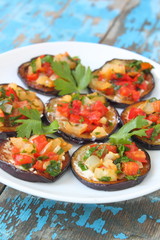 snack from tomato and an eggplant with sauce and greens