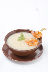 Potato cream soup with glazed shrimp on a skewer, vertical