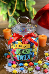 Paper stars with dreams in jar on table on wooden background