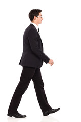 Walking businessman in black suit.