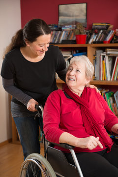 Seniorin im Rollstuhl mit Angeh&ouml;riger
