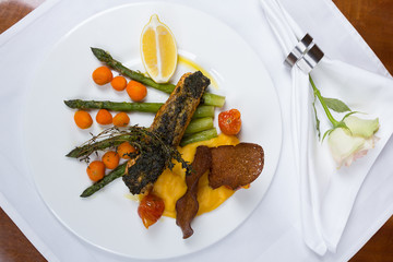 Grilled salmon served with asparagus shoots and cherry tomatoes