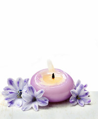 Fototapeta na wymiar Świece zapachowe i fioletowe kwiaty hiacynt