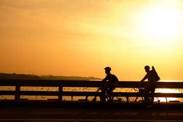 Fototapeta na wymiar Silhouette of the biker on the bridge in sunset