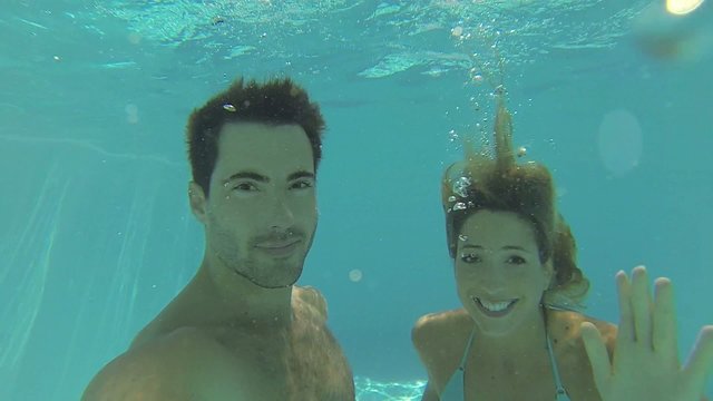 Couple diving underwater in swimming-pool