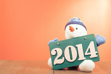 New Year greeting card with snowman and date signboard