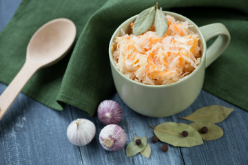 Sauerkraut and ingredients on a wooden table, horizontal shot