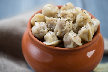 Boiled pelmeni with black pepper, close-up, horizontal shot