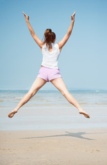 Obraz premium Woman jumping on the beach
