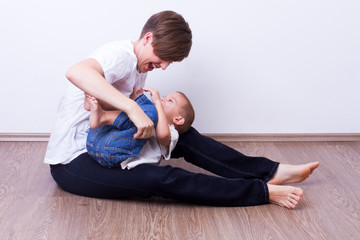 Fototapeta premium Mother tickling her son