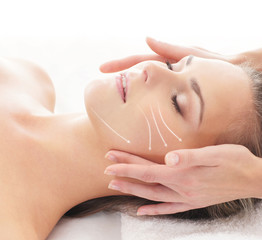Portrait of a young woman laying on a face massage procedure